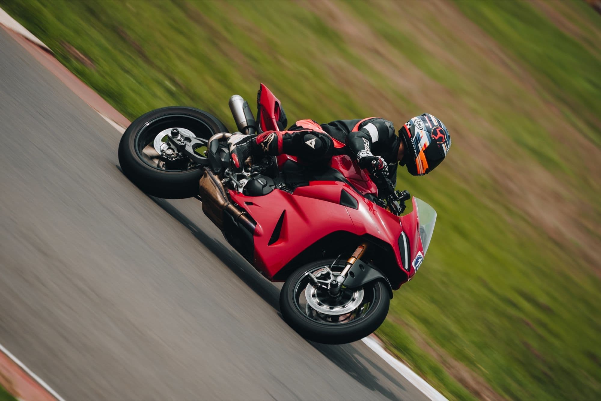 A red motorcycle leaned into a corner, seen from above